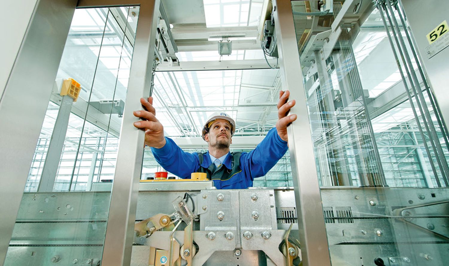 Professional elevator technician working on modern lift system
